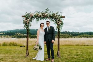Newlyweds standing at the wedding arch