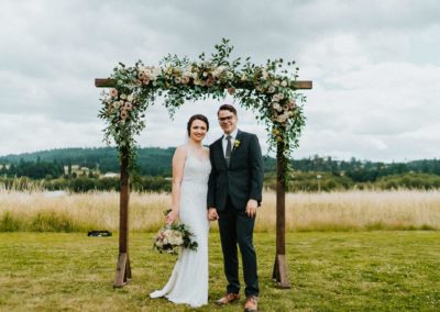 Newlyweds standing at the wedding arch