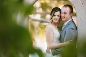 A bride and groom hold each other at the archway