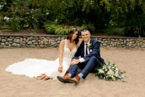 The newlyweds sitting on the sand