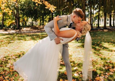 Newlyweds kissing under a tree