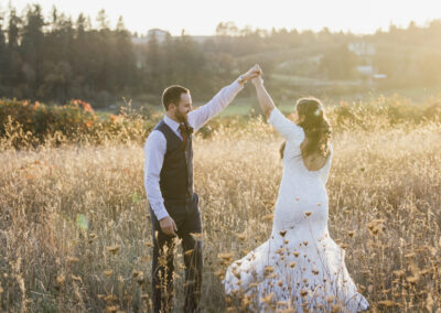 A bride and groom dancing in the meadow