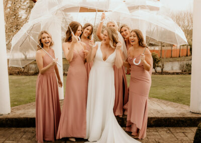 The bride with her bridesmaids holding umbrellas